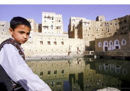 Un niño observa una antigua cisterna de agua en la ciudad yemení de Hababa.