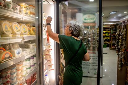 Una mujer elige productos refrigerados en una tienda Korin. 