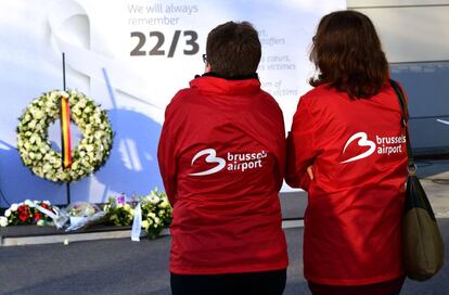 Empleadas del aeropuerto de Bruselas junto al altar improvisado durante el homenaje a las 32 víctimas de los atentados yihadistas del 22 de marzo de 2016.