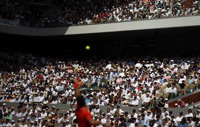 Los espectadores siguen el saque de Novak Djokovic.