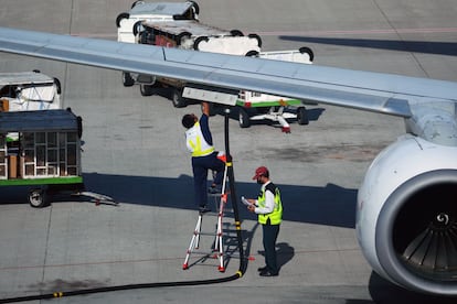 Operarios cargan combustible en un avión comercial.