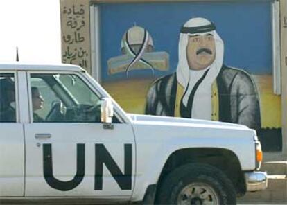Un vehículo de Naciones Unidas pasa frente a una imagen de Sadam Husein en Bagdad.