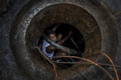 Un trabajador del departamento de telefonía repara los cables subterráneos, en Gauhati, India.