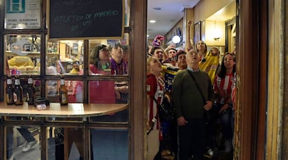 Aficionados atentos a un partido del Atlético de Madrid en un bar.