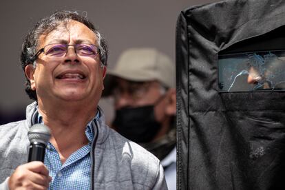 Gustavo Petro, junto a un guardía de seguridad que sostiene un escudo para protegerlo durante su cierre de campaña en Zipaquirá, 22 de mayo de 2022.