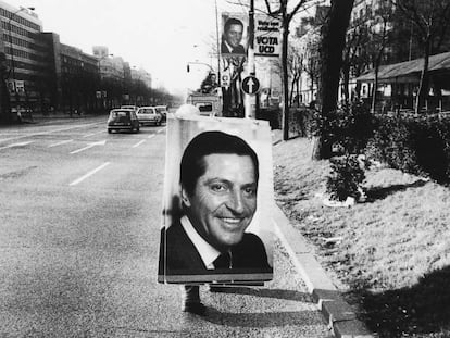 Un operario transporta por el Paseo de la Castella en Madrid un cartel electoral de Adolfo Suárez (1979).