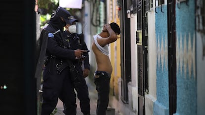 A police officer searches a man in Soyapango, El Salvador