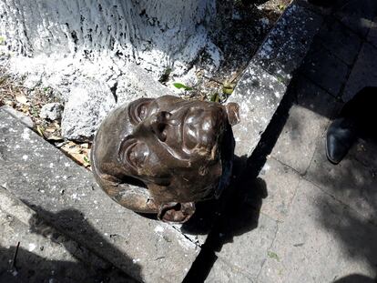 La cabeza derribada de la estatua del obispo Antonio de San Miguel yace en el piso en Morelia, Michoacán, este lunes.