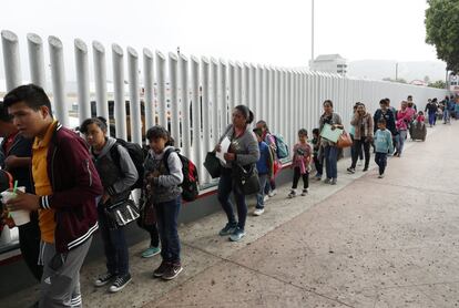 La secretaria de Seguridad Interior, Kirstjen Nielsen, dijo el martes que el gobierno busca "reunificar a todas las familias elegibles". En la imagen, un grupo de migrantes espera a cruzar la frontera de Estados Unidos para comenzar el proceso de solicitud de asilo, entre Tijuana y San Ysidro.