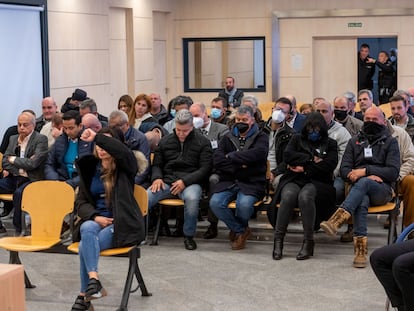 Una parte de los acusados en el macrojuicio, con Ana María Cameno sentada en primera fila, tapándose el rostro con el brazo.