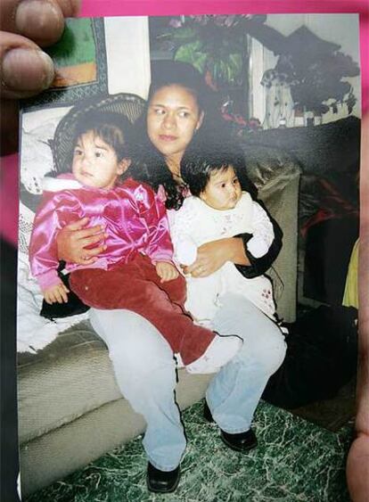 Una vecina muestra fotos de la madre y de sus hijas Janet y Magaly Frayre.