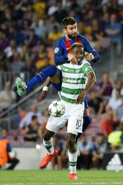 El defensa del Barcelona Gerard Piqué agarra a Moussa Dembele del PSV.
