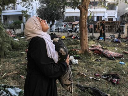 Una mujer sostiene una almohada entre los escombros del hospital Ahli Arab, en el centro de Gaza, el 18 de octubre, tras la explosión de la noche anterior.