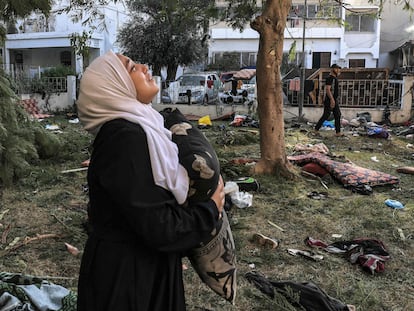 Una mujer sostiene una almohada entre los escombros del hospital Ahli Arab, en el centro de Gaza, el 18 de octubre, tras la explosión de la noche anterior.