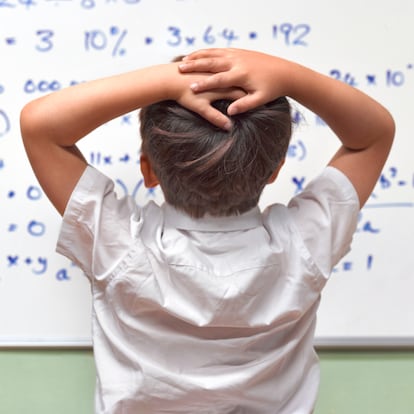 JUNIOR PUPIL AMAZED BY MATHS ON CLASSROOM WHITEBOARD