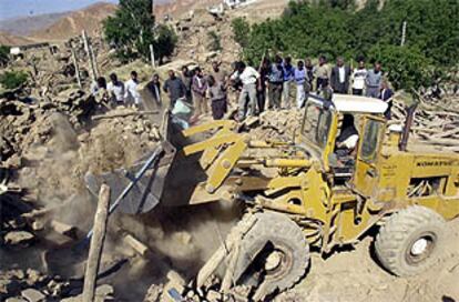 Vecinos de Abdareh (noroeste de Irán) observan a los equipos de rescate que buscan cadáveres entre los escombros.