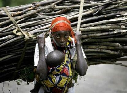 Una mujer acarrea leña en una carretera del este de Congo.