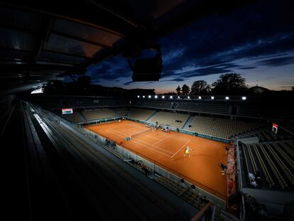 Panorámica de la pista Simonne Mathieu de Roland Garros, con luces artificiales, durante un partido al anochecer entre Khachanov y Majchrzak.