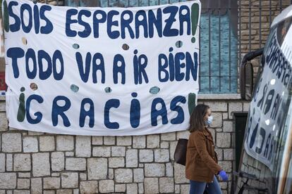 Una mujer pasa junto a un cartel en una calle de Málaga.