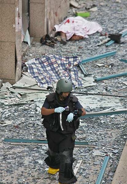 Un artificiero israelí, cerca del cadáver de una víctima, al fondo.
