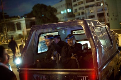 Un vehículo que traslada a policías egipcios es detenido en un puesto de control establecido por vecinos de un barrio de El Cairo, en uno de los extremos de un puente sobre El Nilo.