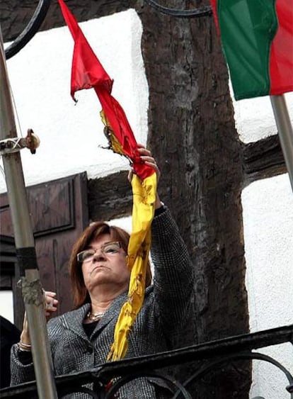 La alcaldesa de Lizartza, Regina Otaola, retira los restos de la bandera española que ondeaba en la fachada del Ayuntamiento y que fue quemada el pasado día 6.