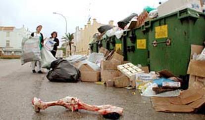 Dos vecinas de Tarifa dejan más basura junto a los desperdicios acumulados tras ocho días de huelga de los servicios municipales.