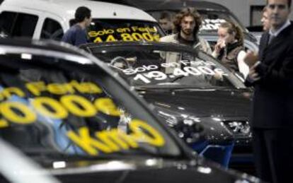 Varias personas contemplan coches de ocasión en una feria de automóviles. EFE/Archivo