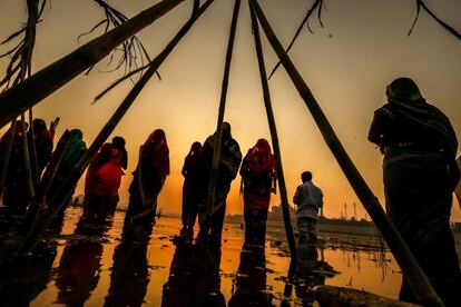 Devotos celebran rituales para venerar la puesta de sol en aguas del río Sabarmati, en Ahmedabad (India).