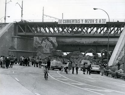 Los curiosos miran cómo el arco central del puente de los Tres Ojos, en la M-30, es demolido por maquinaria pesada tras el fracaso de los explosivos, el 13 de marzo de 1983.