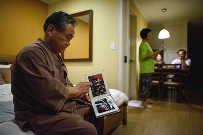 El surcoreano Kim Kun-ho, de 74 años, mira fotos de parientes norcoreanos mientras habla con un periodista de France Presse la víspera de viajar para encontrarse con ellos en una reunión oficial de familias divididas este martes. La reunión se ha celebrado en un hostal cercano a la Zona desmilitarizada que divide la península en dos mitades.