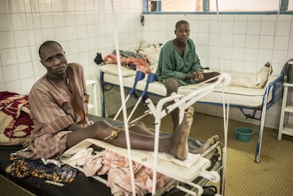 Na sala de feridos por traumatismo do hospital regional de Diffa não cabe mais nenhum paciente. No dia 8 de dezembro, Madou Adji (à esquerda), um camponês de 36 anos, estava na estação de ônibus de Diffa, prestes a tomar um transporte para sua aldeia. Um soldado, supostamente bêbado, atirou em seu pé ao confundi-lo com um membro do Boko Haram. Atrás, Kala Malam, camponês de 18 anos, passou a noite inteira ferido e escondido em uma casa em sua aldeia em Bosso na noite em que foi atacado por radicais. Morreram 22 pessoas. Ele pode contar. “De um ano para cá, atendemos mais de 650 feridos, principalmente vítimas de queimaduras provocadas por explosões, armas brancas e balas”, diz Hamadou Asoumana, chefe de cirurgia. A população civil, como quase sempre acontece, está no meio do conflito.