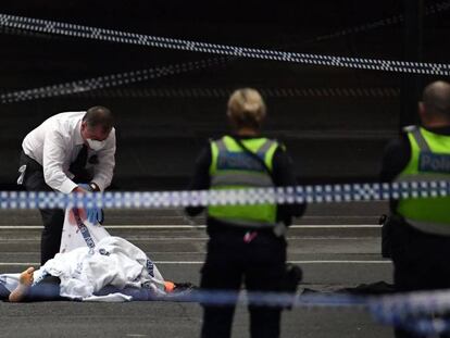 Un policía junto a un fallecido tras el ataque.