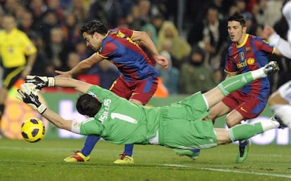 Iker Casillas dives to stop Xavi and David Villa during a Real Madrid-Bar&ccedil;a encounter. 