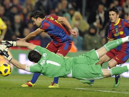 Iker Casillas dives to stop Xavi and David Villa during a Real Madrid-Bar&ccedil;a encounter. 