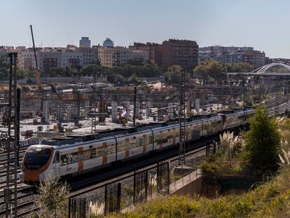 Un tren de cercanías pasa junto a las obras de la estación del AVE de Sagrera en Barcelona.