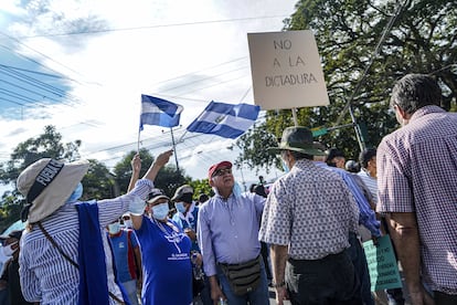 Un manifestante sostiene un cartel que dice "No a la dictadura" durante una protesta en El Salvador.