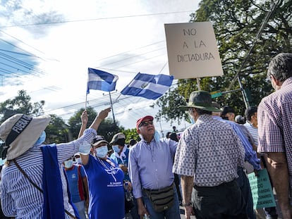 Un manifestante sostiene un cartel que dice "No a la dictadura" durante una protesta en El Salvador.