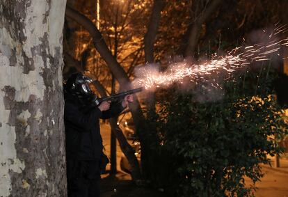 Un agente lanza una lata de gas lacrimógeno durante la protesta, la noche del jueves, en Tbilisi.