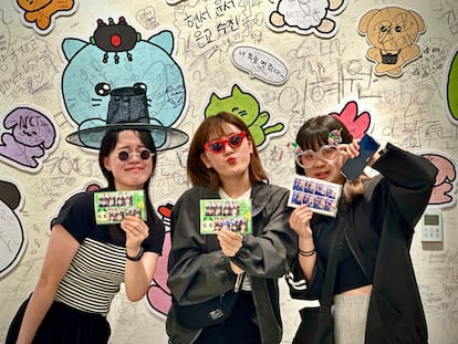 Jinyoung poses with her cousins as they show off their printouts from the photo booth.