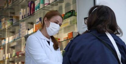 Una farmacéutica atiende a una clienta en el centro de Madrid.