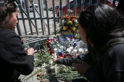 Mujeres colocan flores frente al centro del INM donde estaban detenidos los migrantes.