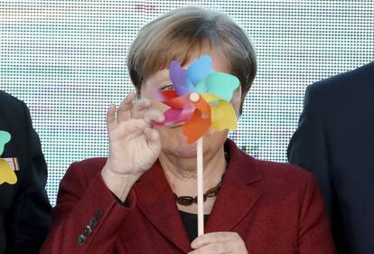 La canciller alemana Angela Merkel, sostiene un molino de viento de juguete, durante la inauguración de un parque eólico marino en el Mar Báltico cerca de la isla Ruegen, en Sassnitz-Mukran (Alemania).