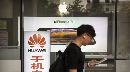 Un hombre consulta su teléfono ante una tienda de Apple en Pekín.
