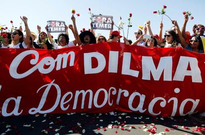 Manifestantes en favor de la presidenta suspendida de Brasil, Dilma Rousseff, protestan frente el Congreso Nacional brasileño con una pancarta que dice: 'Con Dilma y la democracia'.
