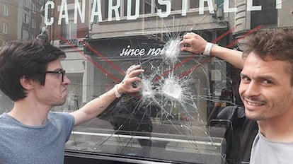 Nicolas y Grégoire, del restaurante francés Canard Street, se fotografían con el escaparate que encontraron roto el 4 de junio de 2018.