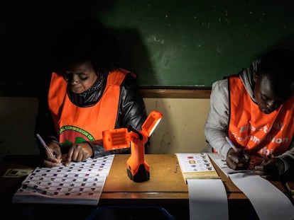 Miembros de la Comisión Electoral de Zambia comprueban el registro de electores y los votos emitidos.