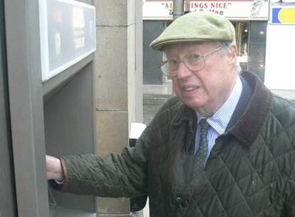 John Shepherd-Barron, el inventor del cajero automático, regocijándose ante su propia obra.