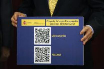 Cristóbal Montoro sujeta un panel con el código QR de los Presupuestos de 2014
