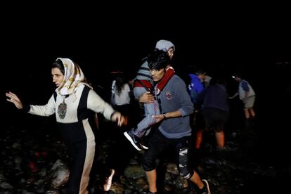 Migrantes afganos desembarcan de un bote en una orilla cerca de la aldea de Skala Sikamias, en la isla de Lesbos (Grecia).